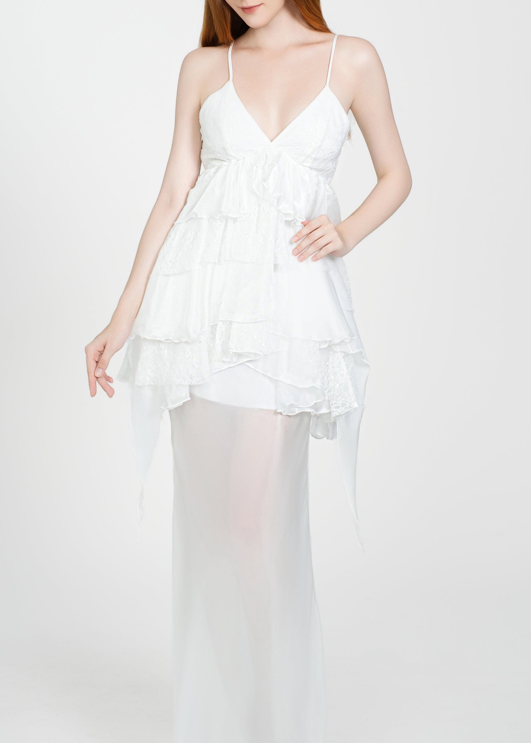 Woman wearing a white dress with sheer overlay on a white background
