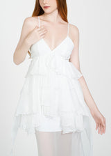 Woman wearing a white lace nightgown against a plain background