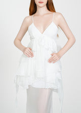 Woman wearing a white lace nightgown on a plain background