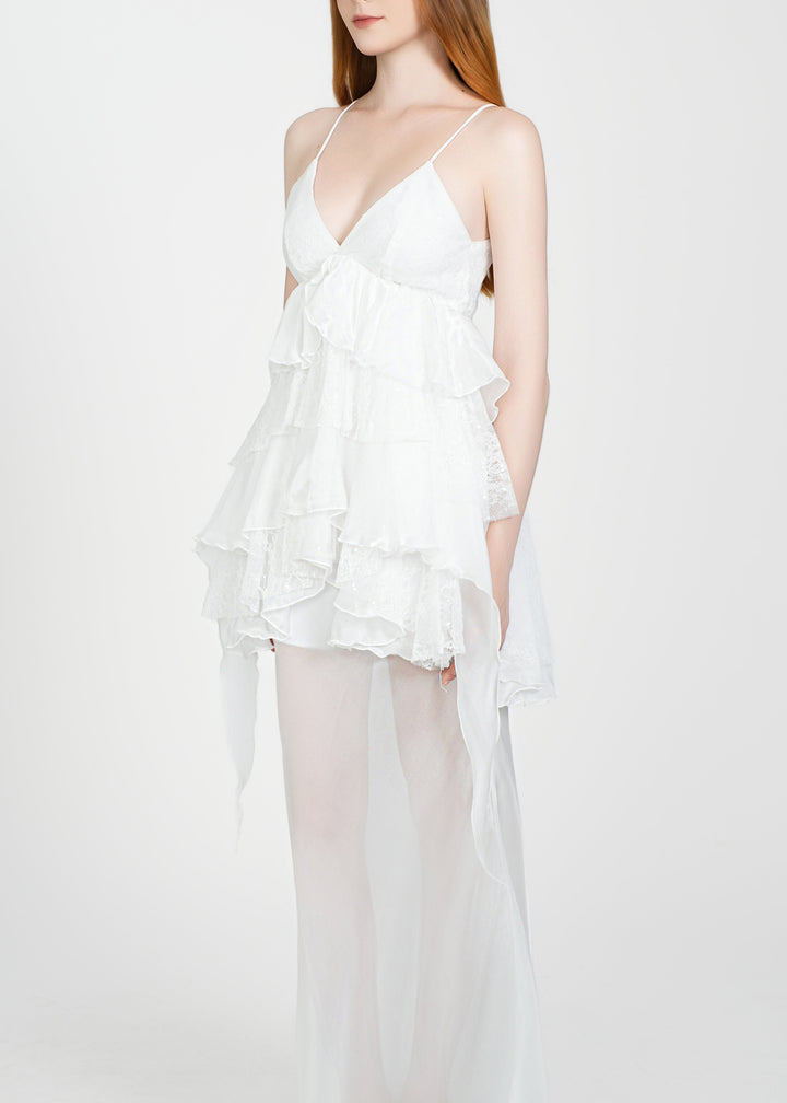 Woman wearing a white dress with sheer overlay on a white background